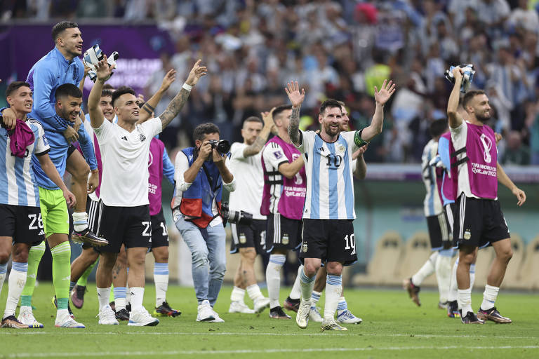 Jogadores argentinos comemoram a vitória sobre o México acenando para a torcida na arquibancada
