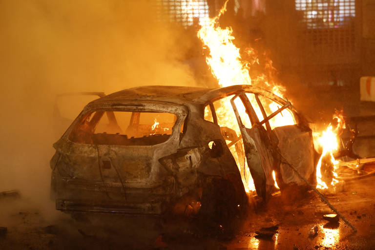 Imagem colorida mostra um carro branco pegando fogo