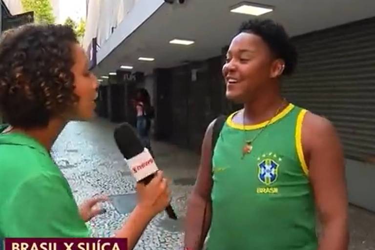 Em foto colorida, repórter entrevista um torcedor antes do jogo do Brasil contra a Suíça