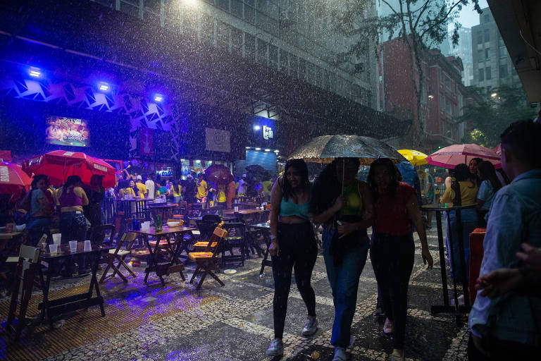 Torcedoras se protegem da chuva na República, região central de São Paulo, na tarde desta segunda (28)