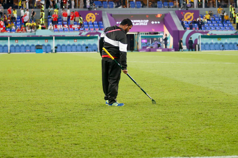 Voluntário arruma gramado do estádio 974, no intervalo da partida entre Brasil e Suíça, na segunda (28)
