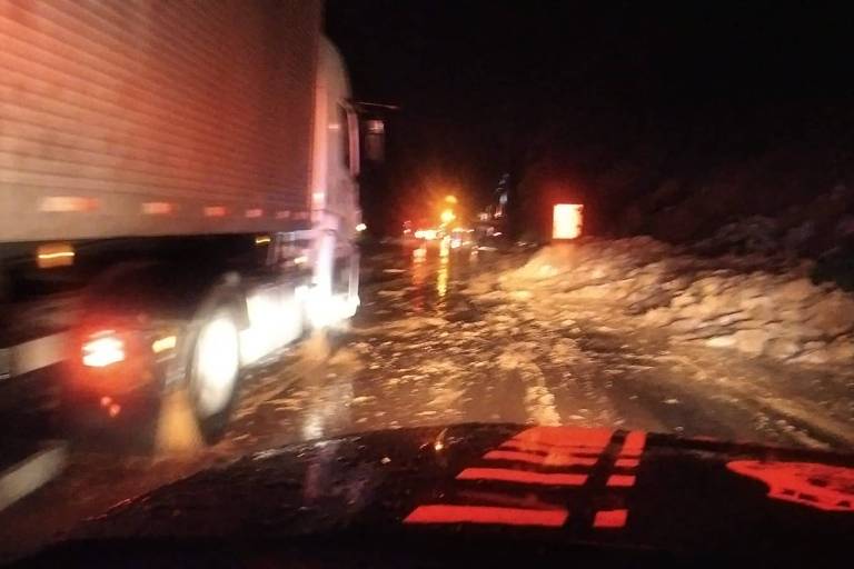 A imagem noturna mostra um caminhão perto de um amontoado de terra em uma estrada