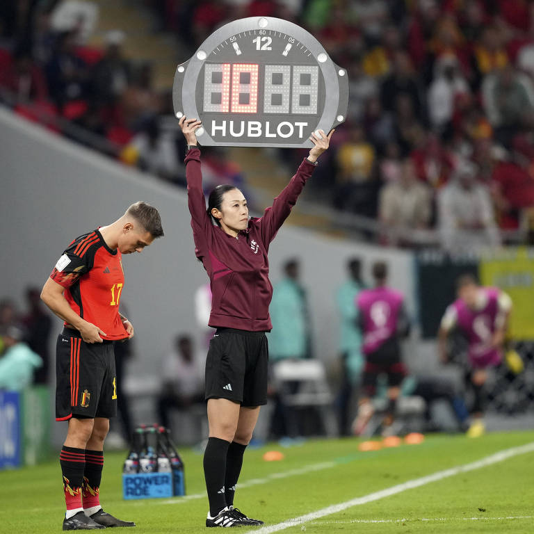 Quarta árbitra em Bélgica x Canadá, a japonesa Yoshimi Yamashita levanta placa que anuncia substituição no time belga na partida da Copa no Qatar