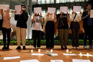 Protest over coronavirus disease restrictions in mainland China, during a commemoration of the victims of a fire in Urumqi, at the HKU, in Hong Kong