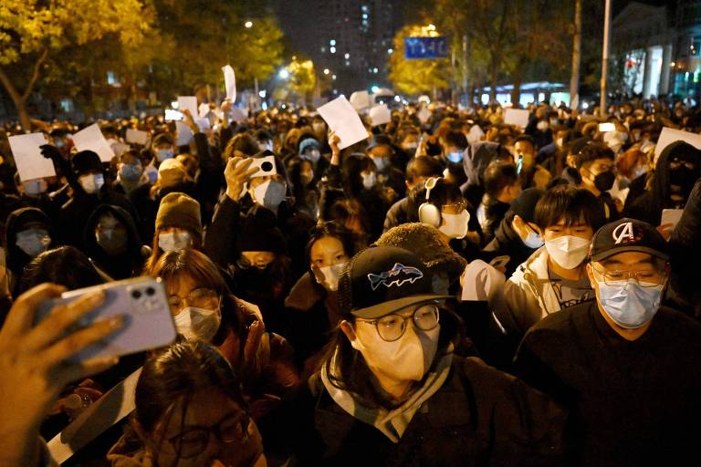 Manifestantes com cartazes em branco, simbolizando a censura do regime, em ato contra a política de Covid zero de Xi Jinping em Pequim