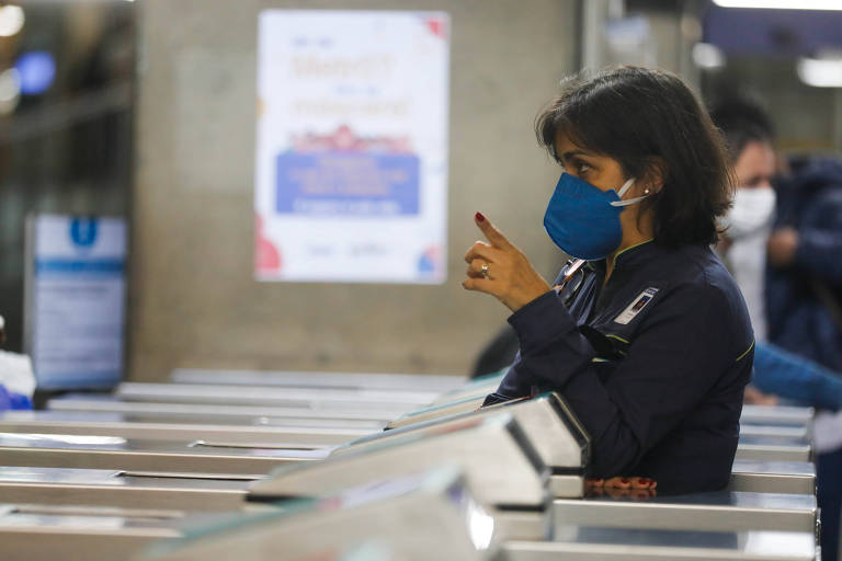 Passageira passa por catraca em estação de metrô em São Paulo; uso de máscara voltou a ser obrigatório em razão da alta no número de casos