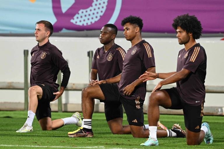 Da esquerda para a direita, estão ajoelhados os alemães Götze, Moukoko, Adeyemi e Gnabry, durante treino em Al Shamal para o jogo decisivo contra a Costa Rica na Copa do Qatar