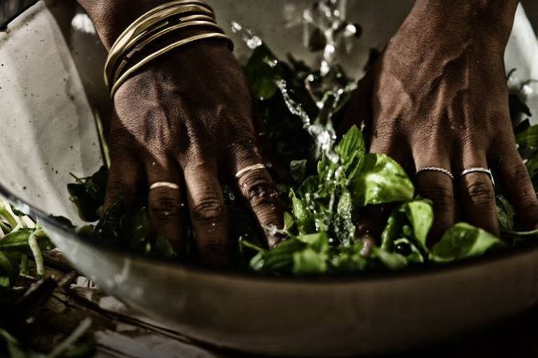 Mãos negras amassam ervas em preparação no terreiro Ilê Omolu Oxum, em São João de Meriti