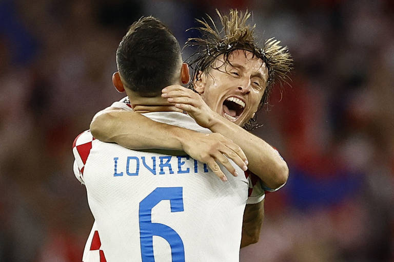 Os croatas Luka Modric e Dejan Lovren comemoram após a partida, classificando a Croácia para a fase eliminatória