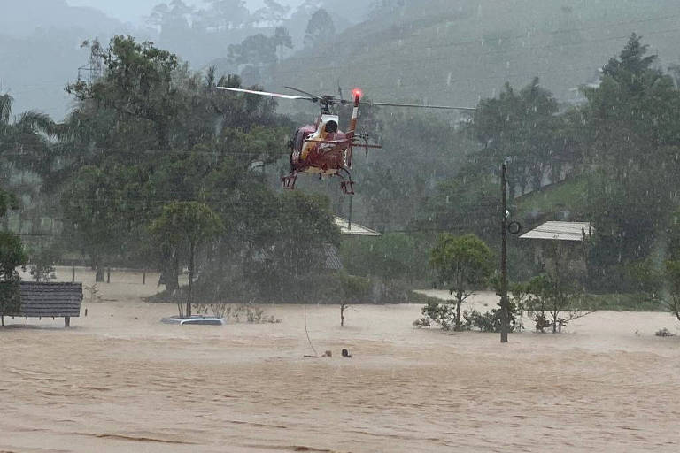 Helicóptero puxa morador em área alagada