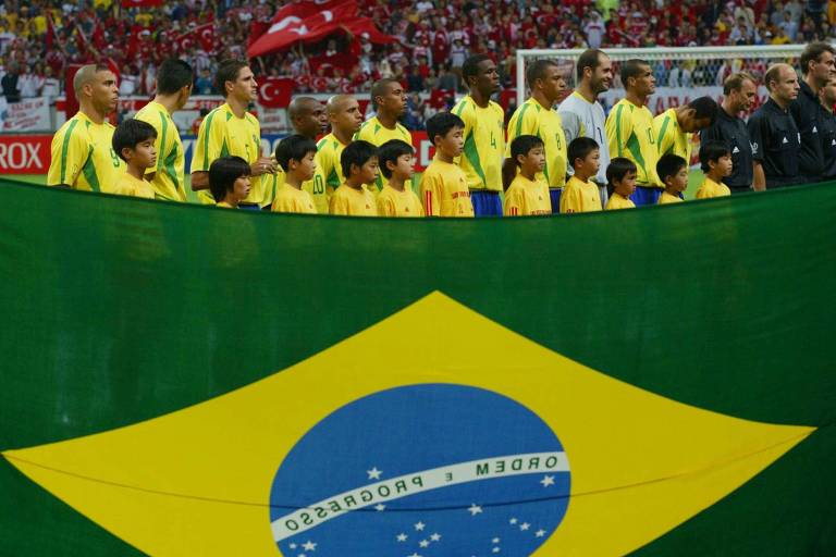 Jogadores da seleção brasileira durante execução do hino nacional  no estádio de Saitama, no Japão, na semifinal da Copa de 2002