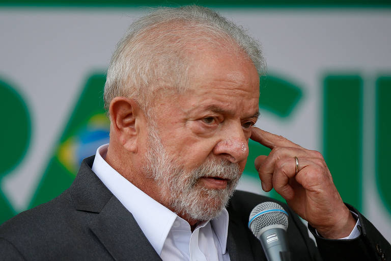 O presidente eleito Luiz Inácio Lula da Silva conversa com jornalistas sobre a transição de governo, no CCBB, sede do governo de Transição.Ele é um homem branco, grisalho. Veste um terno cinza e camisa branca.