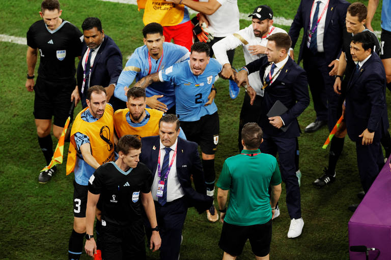 Jogadores uruguaios protestam com o árbitro Daniel Siebert após a partida onde venceram por 2 x 0 de Gana