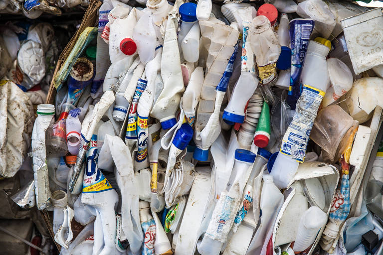 Imagem mostra embalagens plásticas separadas em lotes para reciclagem em um depósito