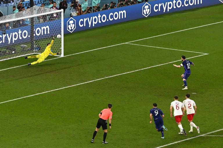 O goleiro polonês Szczesny salta para a esquerda e espalma pênalti batido pelo argentino Messi no estádio 974, em Doha, na Copa no Qatar