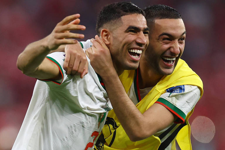 Sorrindo e abraçados, Hakimi e Ziyech, que usa um colete amarelo comemoram no estádio Al Thumama, em Doha, a vitória sobre o Canadá que classificou Marrocos para as oitavas de final da Copa