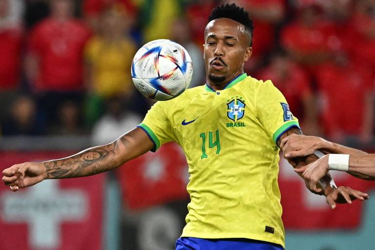 Usando a camisa amarela da seleção brasileira com o número 14 na altura do peito, Éder MIlitão domina a bola contra a Suíça na Copa do Qatar