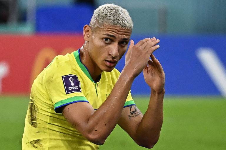 Com a camisa amarela da seleção brasileira, o atacante Richarlison ergue os braços ao lamentar chance desperdiçada contra a Suíça na Copa do Qatar