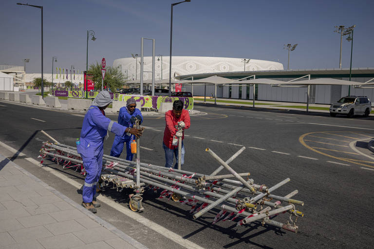 Operários migrantes do lado de fora do estádio Al Thumana, em Doha; as más condições de trabalho, como o forte calor, foram muito criticadas pelos defensores dos direitos humanos