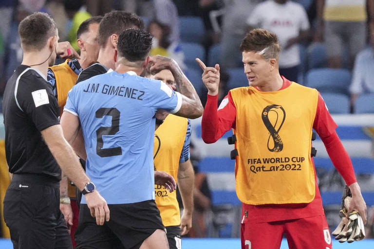 Jogadores uruguaios cobram o árbitro Daniel Siebert após o jogo contra Gana
