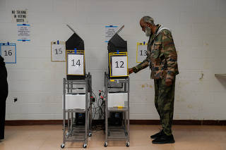 Voters line up to cast their ballots for the U.S. Senate runoff election in Columbus