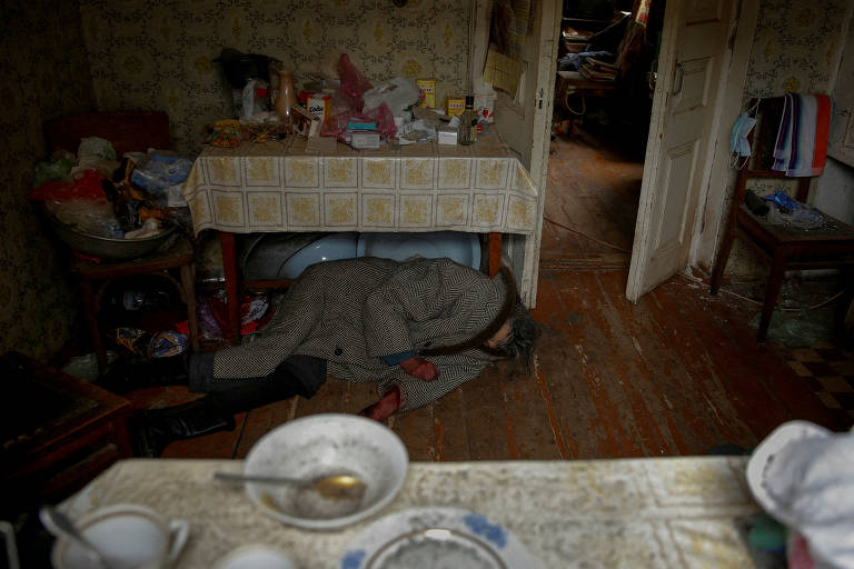 Corpo de mulher no chão da sua casa em Bucha, próximo a Kiev, na Ucrânia