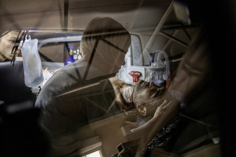 Homem deitado e ferido durante bombardeio em Sloviansk conversa com esposa em veículo de emergência