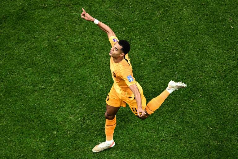 Com o uniforme todo laranja e correndo com os braços abertos, Gakpo comemora seu gol diante do Qatar na vitória da Holanda no estádio Al Bayt, em Al Khor, na Copa do Qatar