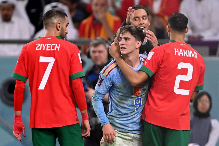 Gavi entre os marroquinos Ziyech, que usa a camisa 7, e Hakimi, que usa a camisa 2, no jogo em que a Espanha deu adeus à Copa de 2022, no Qatar