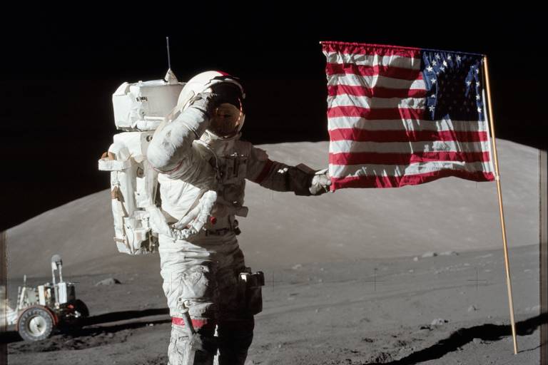 O astronauta Eugene A. Cernan, comandante da missão Apollo 17, é ao lado da bandeira dos Estados Unidos durante atividade extraveicular na superfície lunar, em 7 de dezembro de 1972
