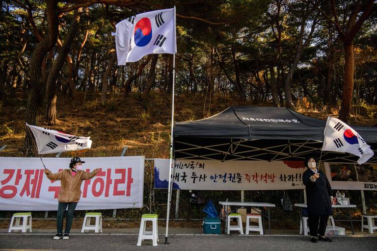 Manifestantes agitam bandeira da Coreia do Sul em estrada na pequena vila de Pyeongsan, em Yangsan