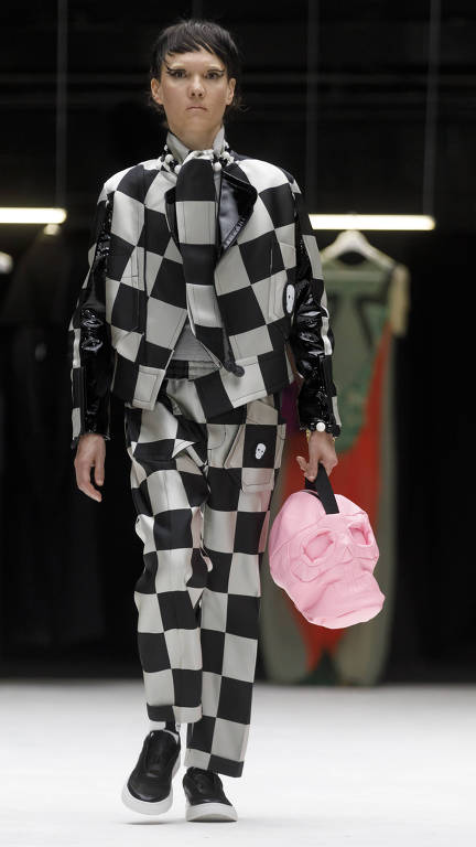 modelo desfila com roupa xadrez preto e branca