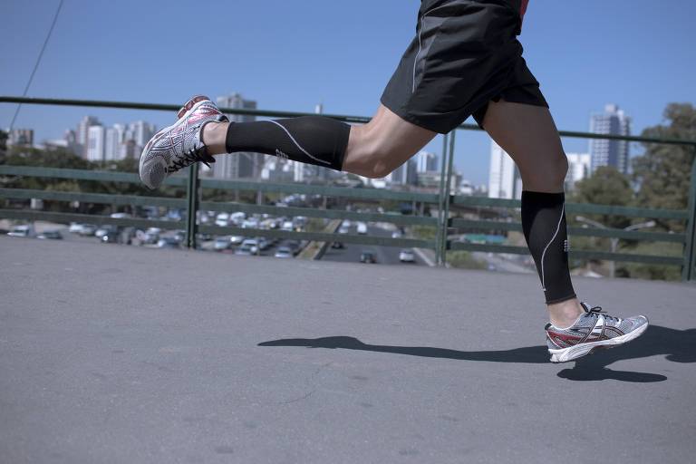 Imagem das pernas de atleta com meias na panturrilha durante corrida