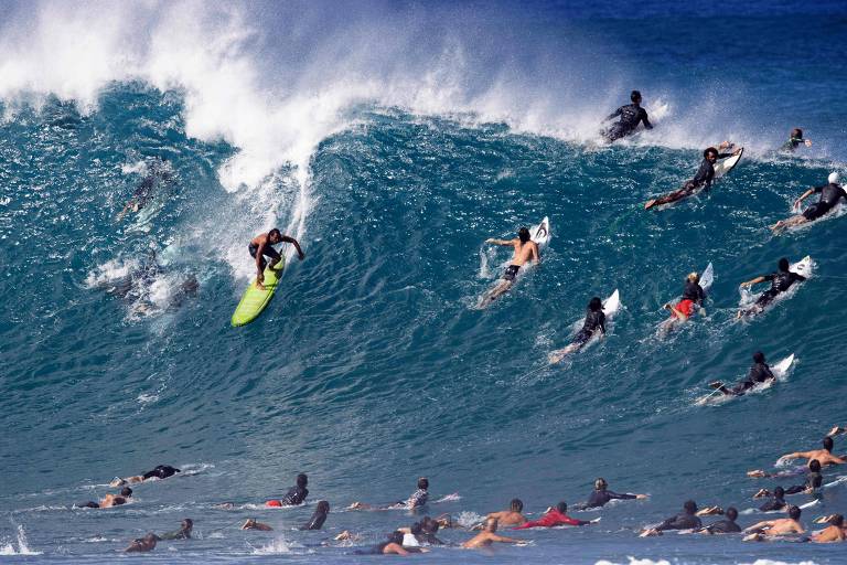 vários surfistas disputam a mesma onda