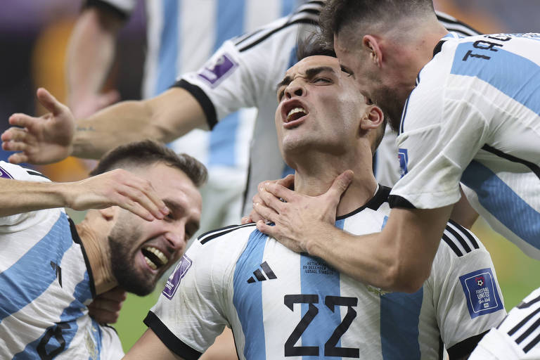 Lautaro Martínez é abraçado pelos demais companheiros na comemoração da classificação da Argentina para a semifinal da Copa do Mundo do Qatar