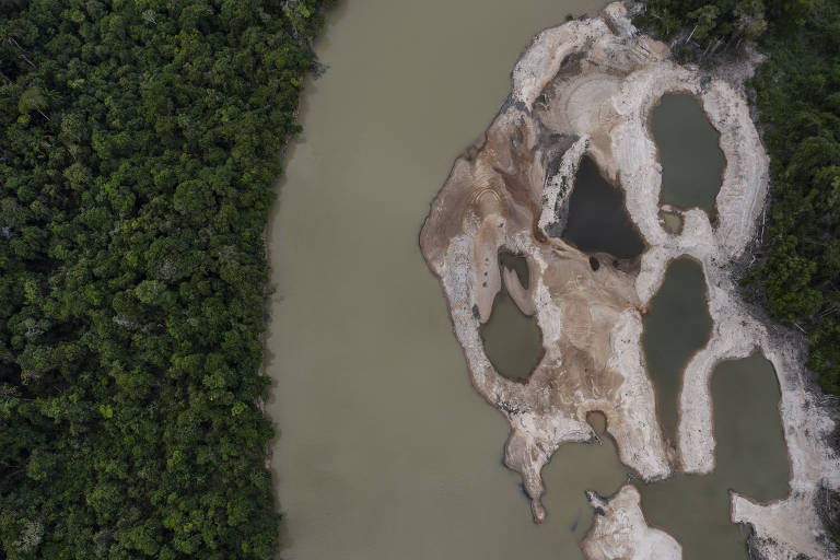 Vista de drone de um rio com grandes manchas de terra no lado direito