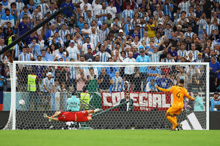 O holandês Van Dijk cobra o pênalti à meia altura, sem muita força, e o goleiro argentino Martínez pula no canto e defende em disputa de penalidades nas quartas de final da Copa do Qatar