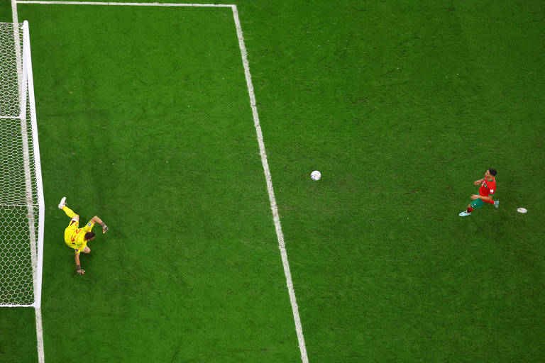 Hakimi arrisca uma 'cavadinha' e a bola se encaminha para entrar no meio do gol enquanto o goleiro Unai Simón cai para a direita na disputa de pênaltis entre Marrocos e Espanha nas oitavas de final da Copa no Qatar