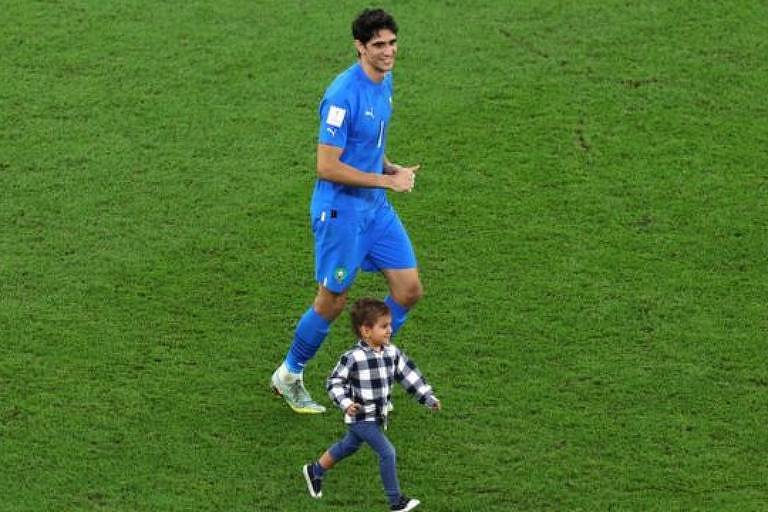 Yassine Bounou comemora com filho vitória do time por 1 a 0 após partida entre Marrocos e Portugal