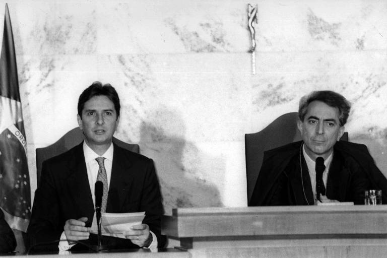 Imagem em preto e branco mostra Fernando Collor de Mello discursando na cerimônia de sua diplomação, ao lado do presidente do TSE, Francisco Rezek