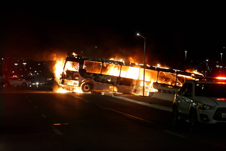 Foto mostra um ônibus em chamas durante a noite, um dos muitos veículos que foram queimados por militantes bolsonaristas na noite desta segunda-feira (12)