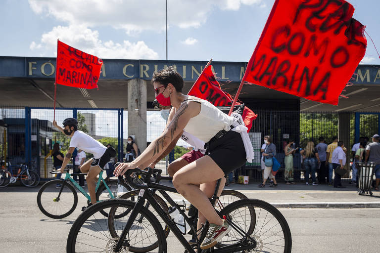 Mulher pedalada com uma bandeira onde se lê "pedale como Marina"