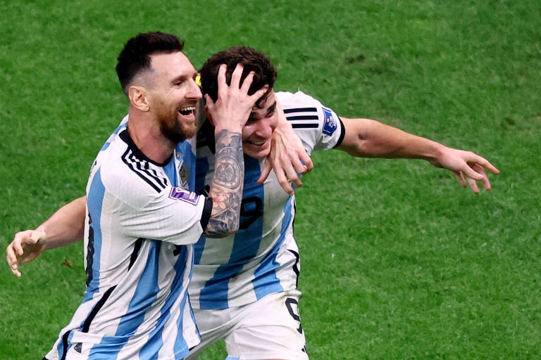 Sorrindo, Lionel Messi  põe a mão direita na cabeça de Julián Álvarez depois do terceiro gol da Argentina contra a Croácia
