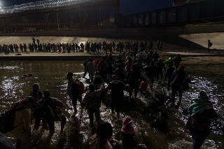 Migrants, mostly from Nicaragua, cross the border at Ciudad Juarez, Mexico, to turn themselves in to U.S. Border Patrol agents and request asylum in El Paso, Texas, Dec. 11, 2022. (Paul Ratje/The New York Times)