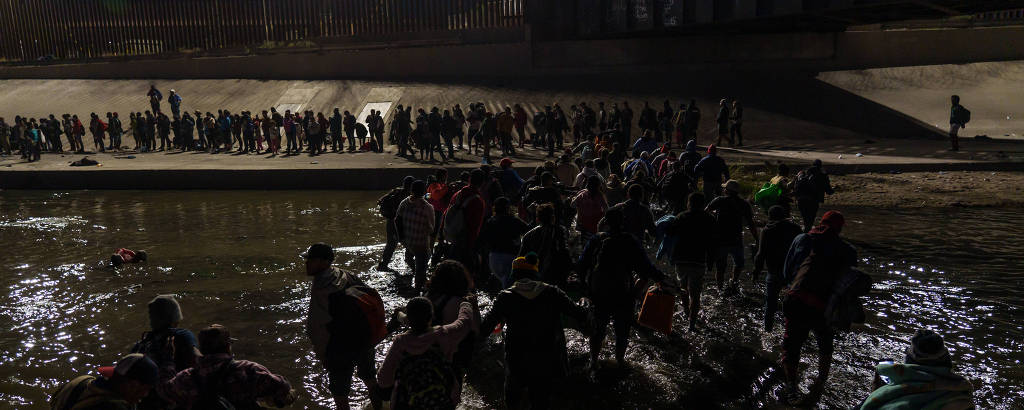 Dezenas de migrantes cruzam fronteira do México com os EUA antes de solicitarem asilo em El Paso, no Texas
