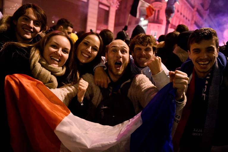 Torcedores comemoram após a vitória da França sobre o Marrocos na semifinal na Champs-Elysées, em Paris