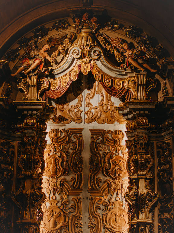 detalhe de altar com tons dourado e marrom, com anjos