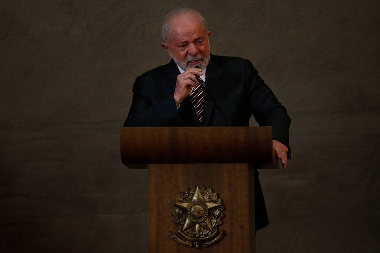 Lula, homem branco, fala ao microfone em púlpito de madeira