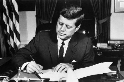 (FILES) In this file photo taken on October 23, 1962, US President John Fitzgerald Kennedy signs the Proclamation for Interdiction of the Delivery of Offensive Weapons to Cuba, ordering a naval blockade of Cuba, at the White House in Washington DC, during the Cuban missile crisis. - October 22, 2022, marks the 60th anniversary of US president John F. Kennedy announcing a naval blockade around Cuba, at the start of the 'Cuban missile crisis.' The 35-day (16 October  20 November 1962) Cuban missile crisis and its aftermath was the most serious US-Soviet confrontation of the Cold War. On October 15, 1962, the US army discovered several Soviet nuclear missile ramps on the island of Cuba. Days later President Kennedy ordered the maritime blockade of the island. After several days of negotiations between Kennedy and Nikita Khrushchev, first secretary of the CPSU, during which the world lived under the threat of nuclear war, the USSR retreats. After coming close to nuclear disaster, the two great powers decide to set up the hotline. (Photo by AFP)