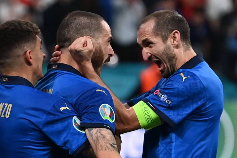 Olhando um para o outro, os italianos Bonucci e Chiellini vibram com a vitória da Itália sobre a Inglaterra na final da  Eurocopa, em 2021